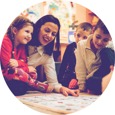 A woman playing a board game with children