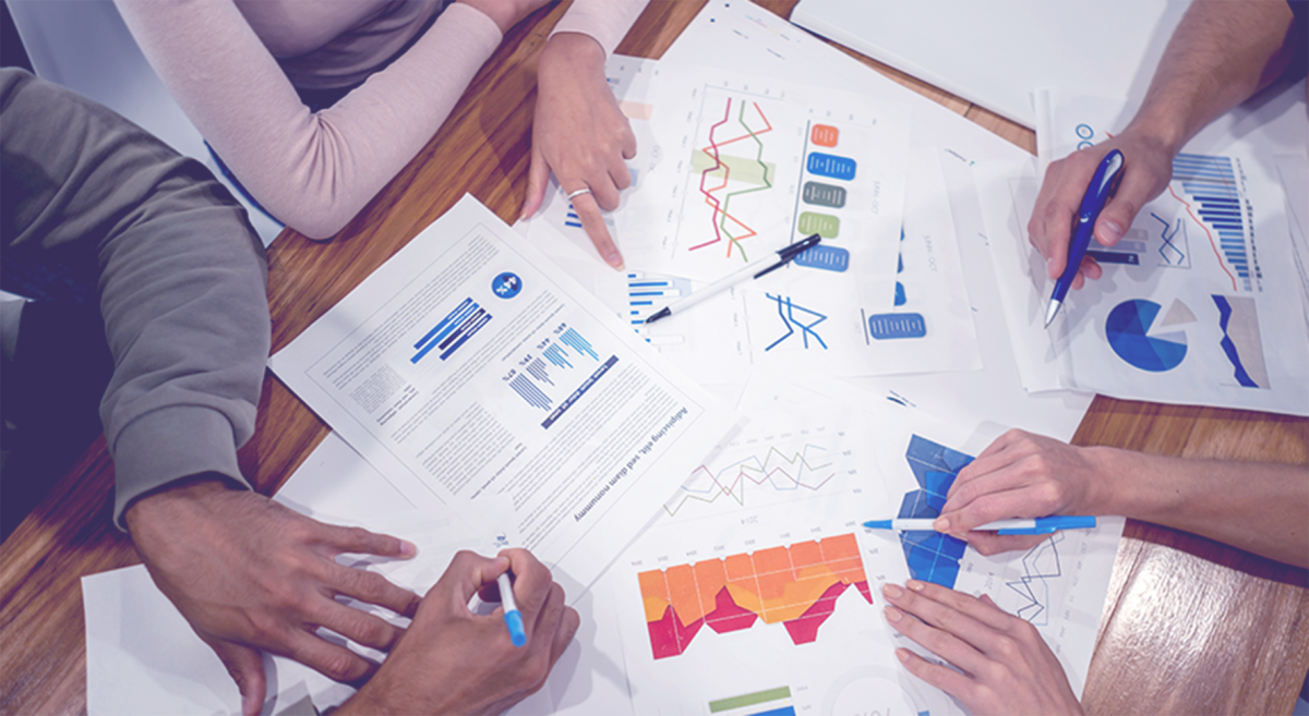 Hands studing and working on a collection of reports